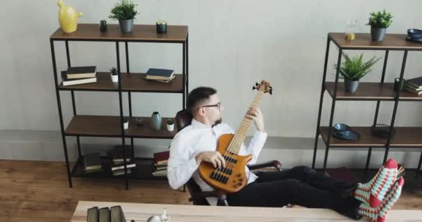 Επιχειρηματίας μουσικός ονειροπόλος ναυαγοσώστης στο γραφείο παίζει κιθάρα αντ 'αυτού εργασία. — Αρχείο Βίντεο