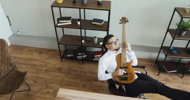 Junger Mann Musiker träumt Lebensstil im Büro spielt Gitarre statt Arbeit. — Stockvideo