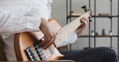 Akustik gitarla çalan müzisyenin elleri, yakın çekim görüntüsü.