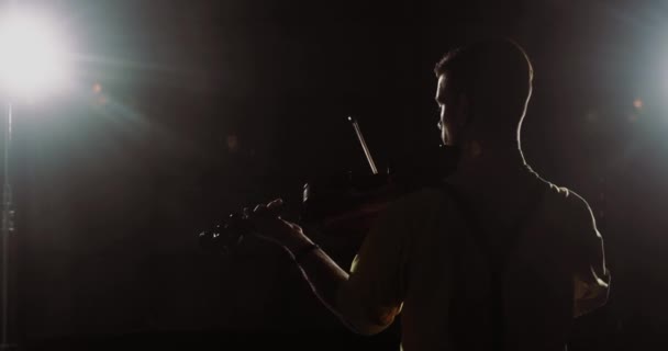 Man professionell violinist framträder från scenen spelar violin, baksida. — Stockvideo