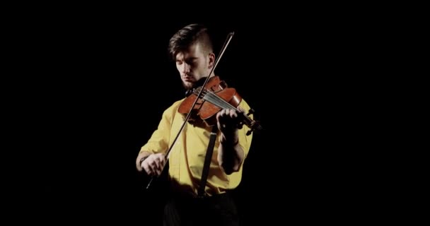 Hombre virtuoso violinista tocando violín sobre fondo negro en oscuro, vista frontal . — Vídeo de stock