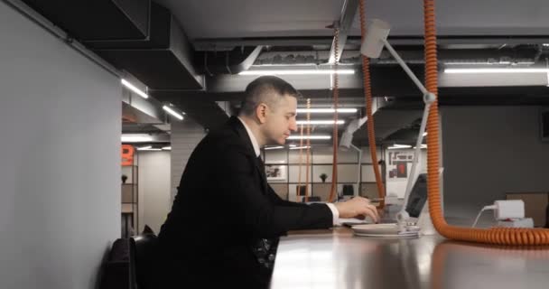 Starší muž office manager pracuje na notebooku sedí v moderním coworking centru. — Stock video