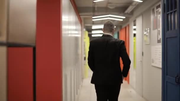 Счастливый бизнесмен менеджер ходить и танцевать в офисном коридоре, вид сзади . — стоковое видео