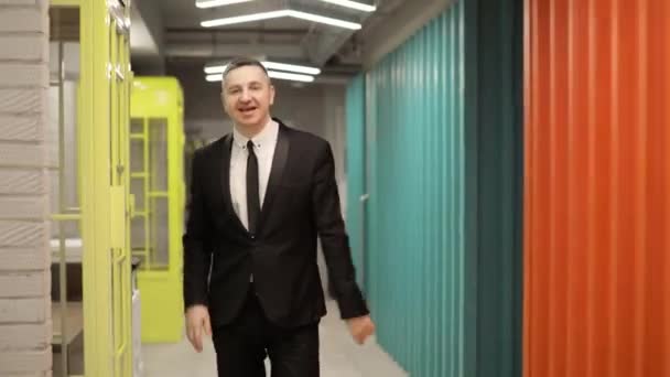 Feliz hombre de negocios caminando en el pasillo de la oficina bailando diciendo que sí, vista frontal . — Vídeo de stock