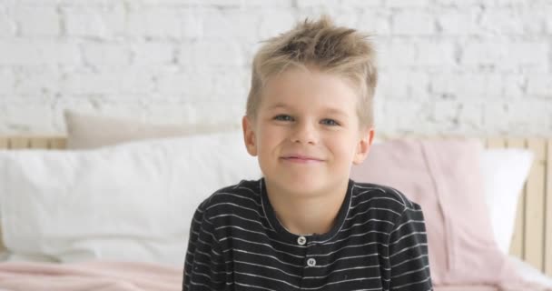 Poratrait de petit garçon souriant de 5 ans regardant la caméra assise dans sa chambre . — Video