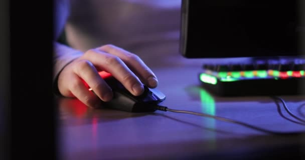 Erkek oyuncu bilgisayar oyunları oynuyor. Fare bastırıyor. Masada oturuyor, elleri yakın.. — Stok video