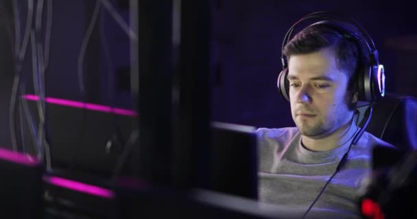 Portrait of man gamer playing computer game in headphone looking at screen . — Stok Video