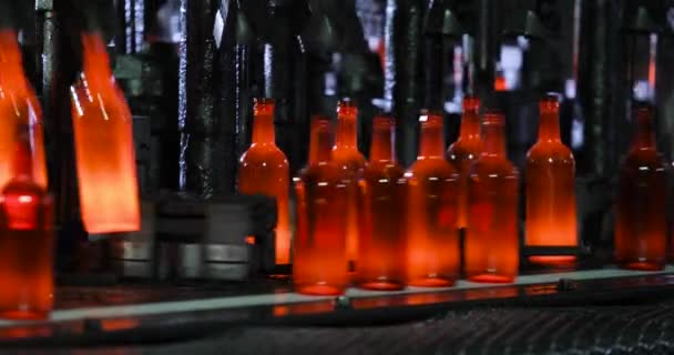 Automated process of forming bottle of molten glass on conveyor line in plant. — Stock Video