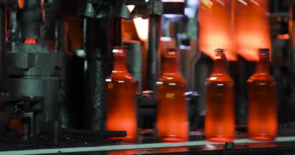 Molten glass mass enters mold and then into glass blower where bottle is formed. — Stock Video