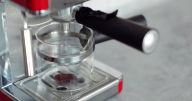 Otomatik kahve makinesinden fincana taze kahve dökülüyor, yakın plan..