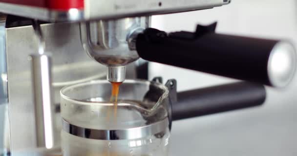 Gorąca kawa wylewa się do filiżanki z automatu do kawy, zaparzając espresso. — Wideo stockowe