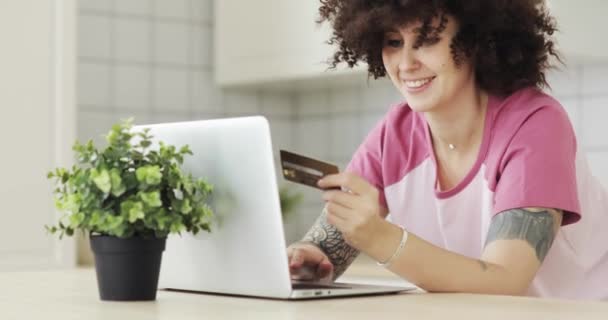 Mujer está haciendo el pago en línea de la celebración de la tarjeta bancaria utilizando portátil moderno en casa . — Vídeos de Stock