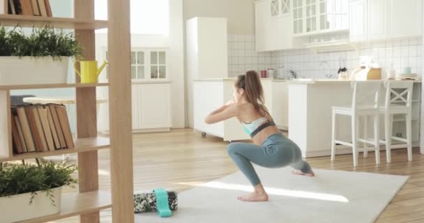Giovane donna sportiva che fa squat per glutei in allenamento affondo laterale a casa . — Video Stock