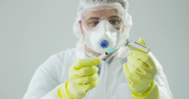 Portrait doctor fills syringe with coronavirus vaccine, preparing for injection. — Stock Video