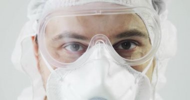 Koronavirüs salgını sırasında koruyucu giysiler içinde bir doktor portresi..