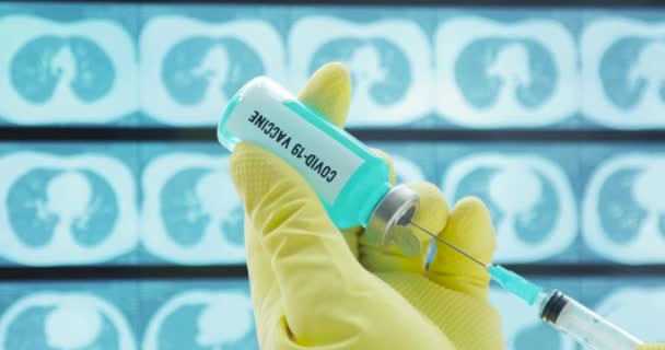 Läkares händer fyller sprutan med coronavirus vaccin, förbereder för injektion. — Stockvideo
