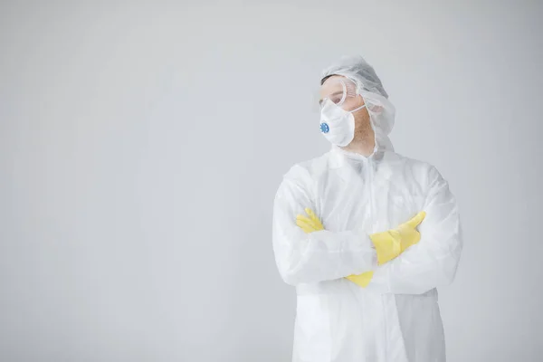 Man in protective suit, mask and glasses coughing, coronavirus pandemic threat.