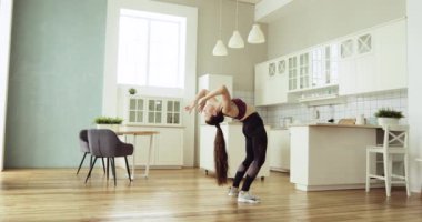 Genç, sağlıklı bir kadın evde briç pozisyonunda yoga yapıyor..