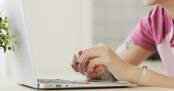 Giovane donna freelance con capelli ricci che lavora su laptop a casa, vista laterale . — Video Stock