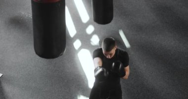 Eldivenli genç boksör spor salonunda boks antrenmanı yapıyor..