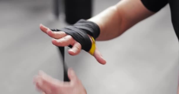 Hombre boxeador envolver las manos antes de luchar o entrenar en el gimnasio, las manos de cerca . — Vídeo de stock