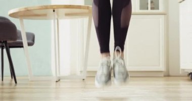 Sportif kadınların bacakları ip atlıyor mutfakta kardiyo antrenmanı yapıyor..