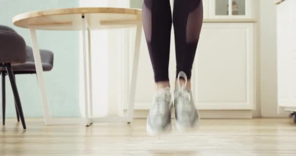 女运动员的腿在厨房里跳钢丝绳，在家里做体操训练. — 图库视频影像