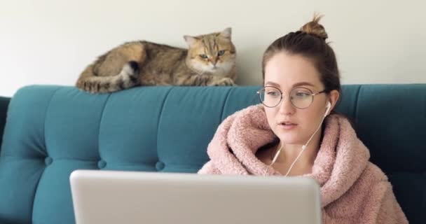 Dívka student nosit sluchátka studium on-line s internetovým učitelem naučit jazyk mluvit při pohledu na notebook, zaměřená mladá žena, aby video hovor — Stock video