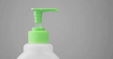 Adam dezenfektanla ellerini temizlemek için şişeye bastırıyor..