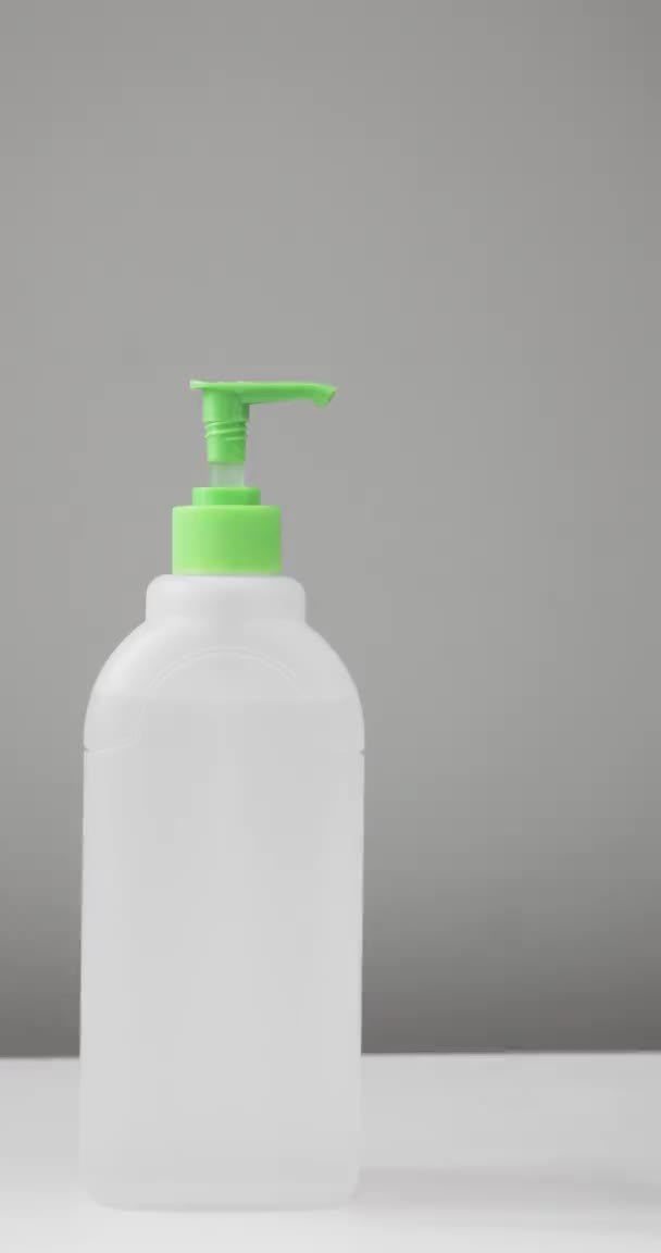Man drukken op doseren fles om handen schoon te maken met ontsmettingsmiddel, verticale video. — Stockvideo