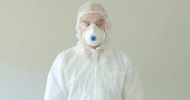 Koruyucu giysili doktor etiketi tutuyor. Coronavirüs salgınında evde kal..
