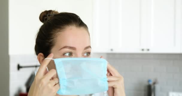 Young girl is wearing medical protective facial mask in quarantne at home. — Stock Video