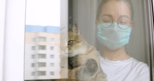 Meisje met masker met kat ontbreekt over normaal normaal leven op quarantaine thuis. — Stockvideo