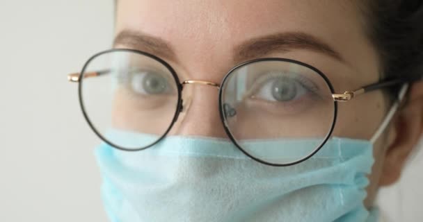 Portrait rapproché de la femme en lunettes et masque médical en cas de pandémie de coronavirus . — Video