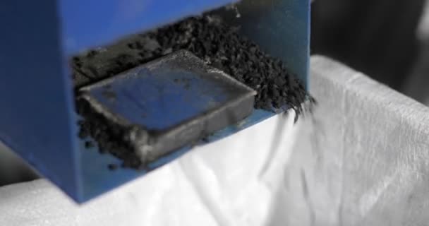 Processus de recyclage des pneus de voiture, miettes de caoutchouc tombant de la machine sur l'usine . — Video