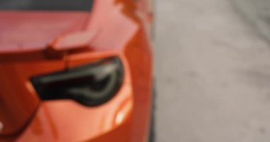 Adam uzaktan kumandalı tuşa basarak arabasını açar..