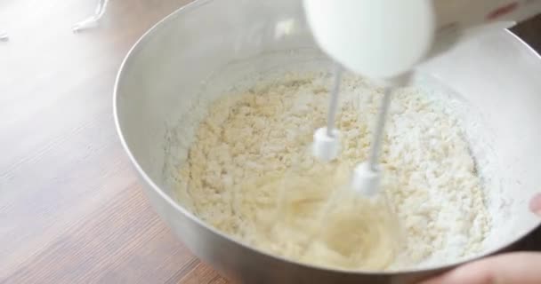 Пекарь смешивания ингредиентов в миске приготовления теста торт выпечки с помощью электрического миксера . — стоковое видео