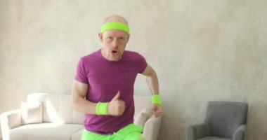 Evde koşan komik bir adamın portresi spor yapıyor, önden bakıyor..