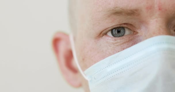 Fechar parte do rosto do homem doente em máscara protetora médica na pandemia de covid-19 . — Vídeo de Stock