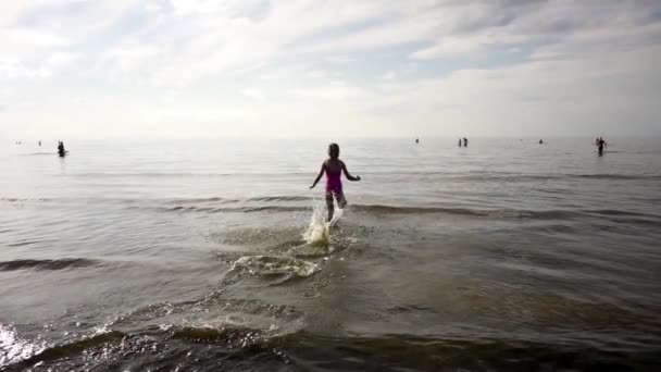 Slow Motion: Beautiful little girl runs on water in Baltic Sea in Jurmala, Latvia. — Stock Video