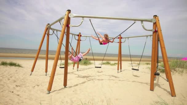 Slow Motion: Dos niñas hermosas en swing Mar Báltico en Jurmala, Letonia . — Vídeo de stock