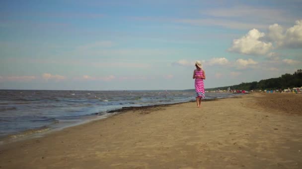 Маленькая красивая девочка гуляет по песчаному пляжу курортного города Юрмала, Латвия . — стоковое видео