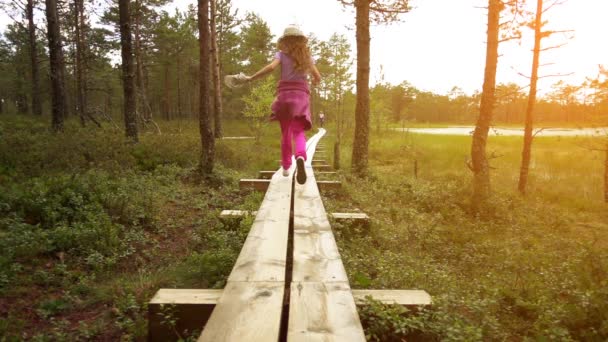 慢动作︰ 美丽的小女孩走上拉，爱沙尼亚病毒 Raba 沼泽字段中. — 图库视频影像