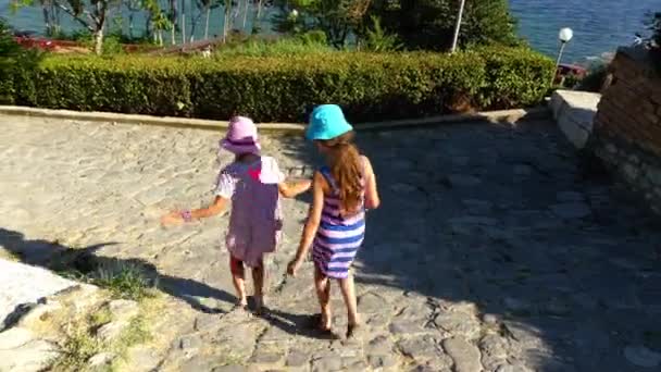 Deux belles petites filles marchent sur Nesebar est une ancienne ville et l'une des principales stations balnéaires de la côte bulgare de la mer Noire, située dans la province de Burgas . — Video