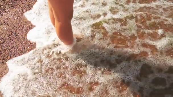 Ralenti : Jambes de fille pieds nus dans le sable sur la plage avec des vagues . — Video