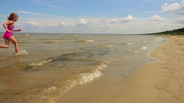 Szép kislány sétál a homokos beach resort city Jurmala, Lettország. — Stock videók