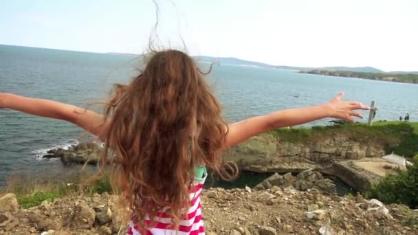 Lilla vackra flicka på steniga stranden av Medelhavet. — Stockvideo