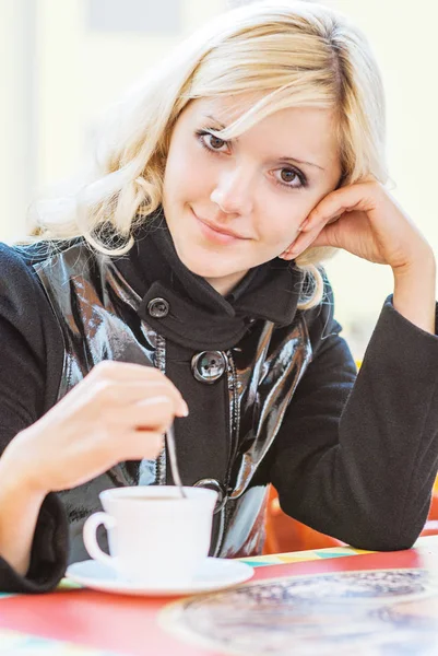 Młoda piękna kobieta siedzi w kawiarni — Zdjęcie stockowe