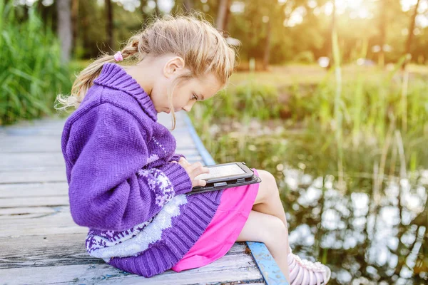Όμορφο κοριτσάκι να διαβάσετε e-βιβλία — Φωτογραφία Αρχείου