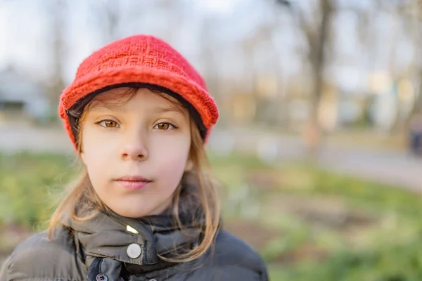 Pequena menina sorridente bonita em chapéu vermelho — Fotografia de Stock